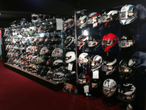 Approximately 80 Motorcycle Helmets on a display wall of a motorcycle dealership